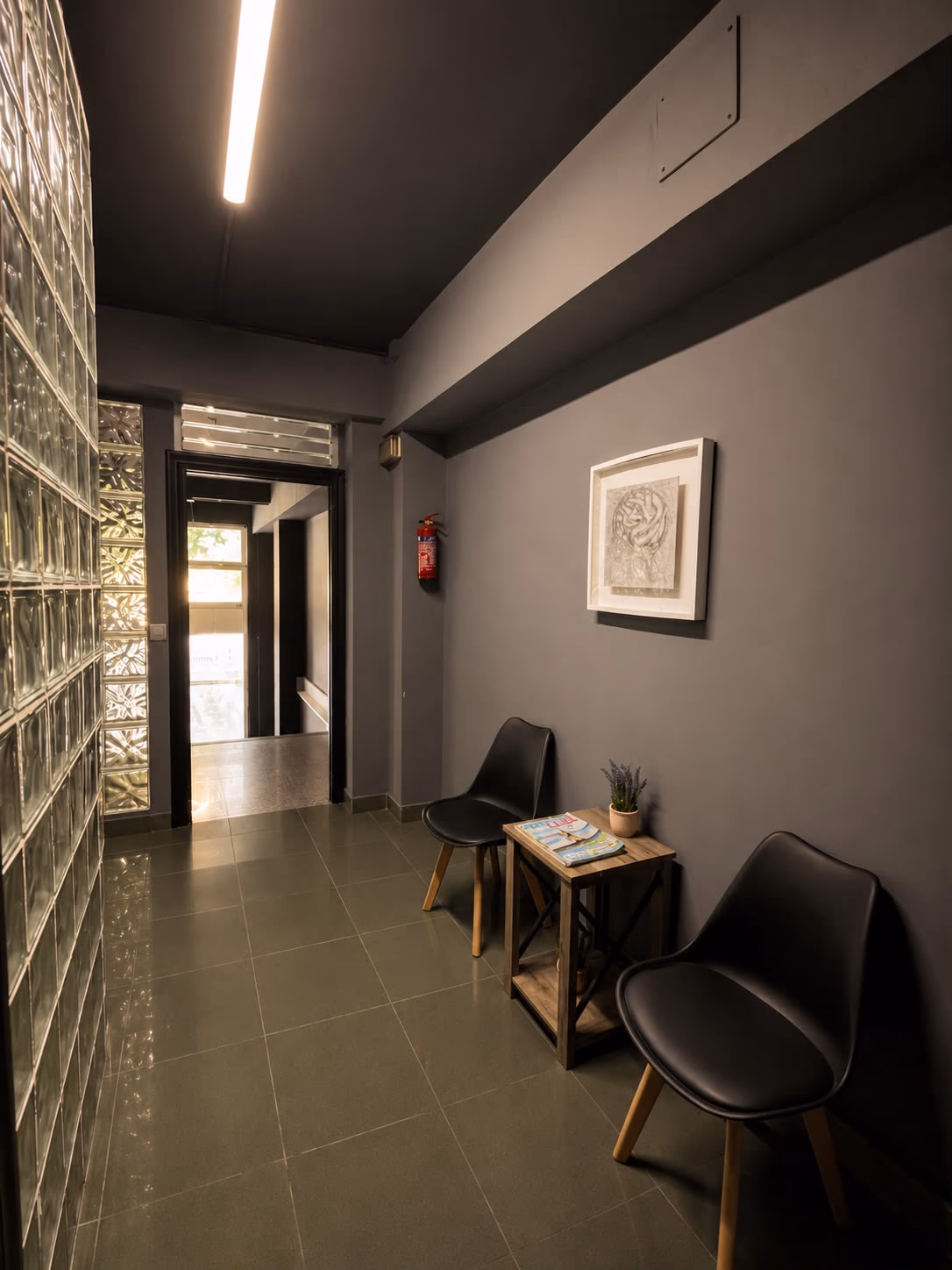 Entrada y recepción de Fitness Center con luz cálida sobre el pavés